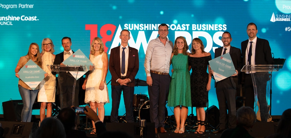 A group of Hall of Fame inductees posing for a photo onstage at the 2018 Sunshine Coast Business Awards.