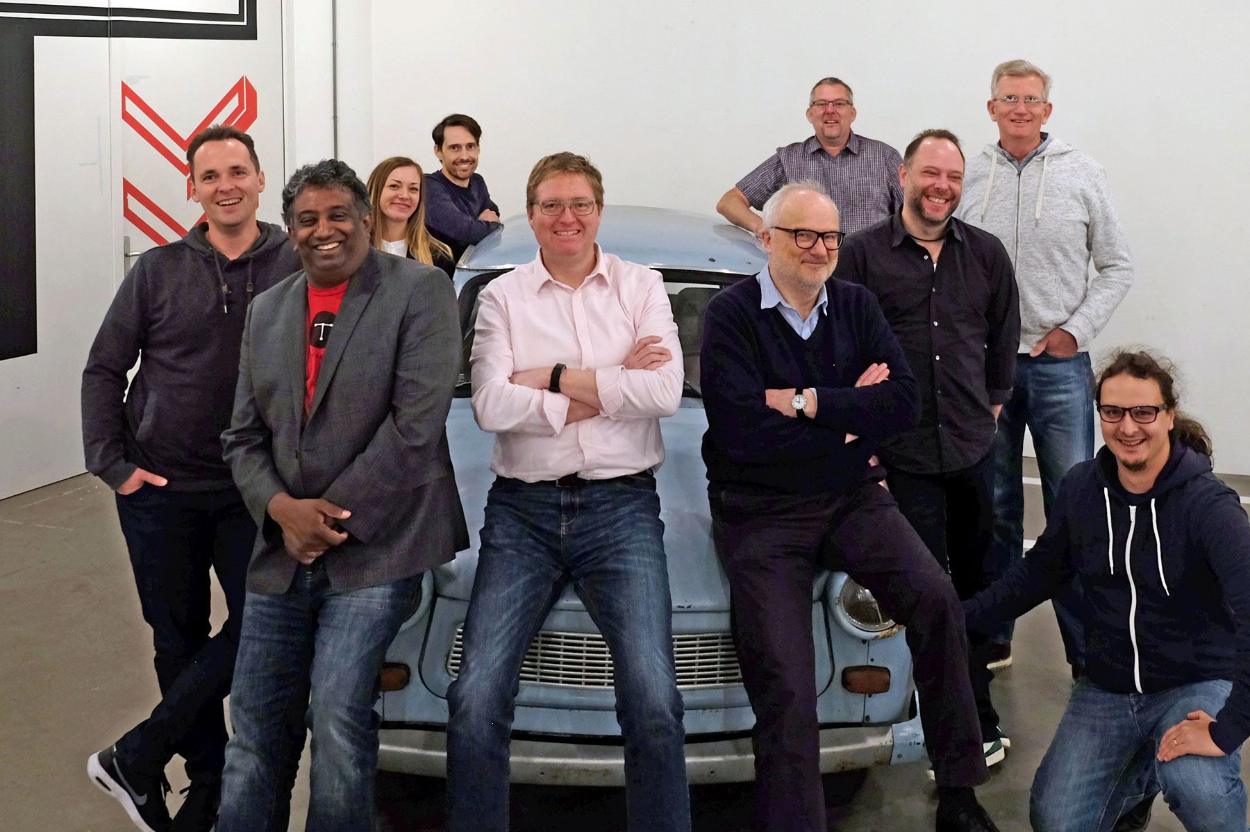 Typefi's EMEA team stand smiling around a classic European car.
