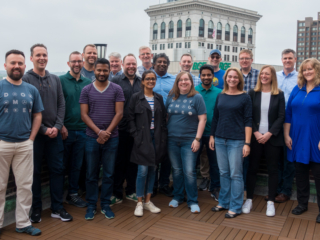 20 Typefi team members standing on a roof deck with other Baltimore buildings visible in the background.