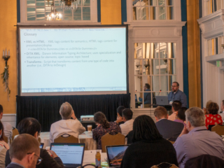 Peyton Bentley presenting at the 2019 Typefi User Conference. The screen shows a glossary of terms from his presentation, including XML vs HTML, DITA XML, and Transforms.