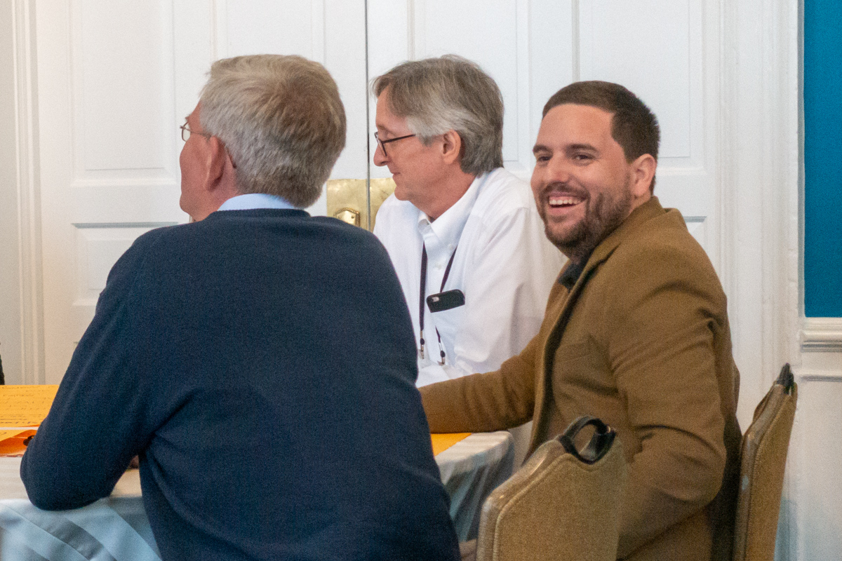 Candid photo of Damian Gibbs, John Muenning and Jaume Balmes seated at a table. Jaume is laughing.