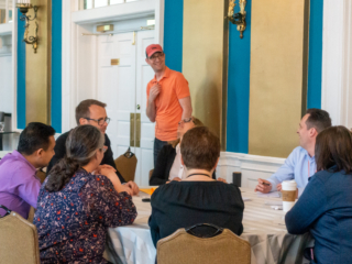 A group of Typefi User Conference guests having a roundtable discussion, with Caleb Clauset looking on cheerfully.