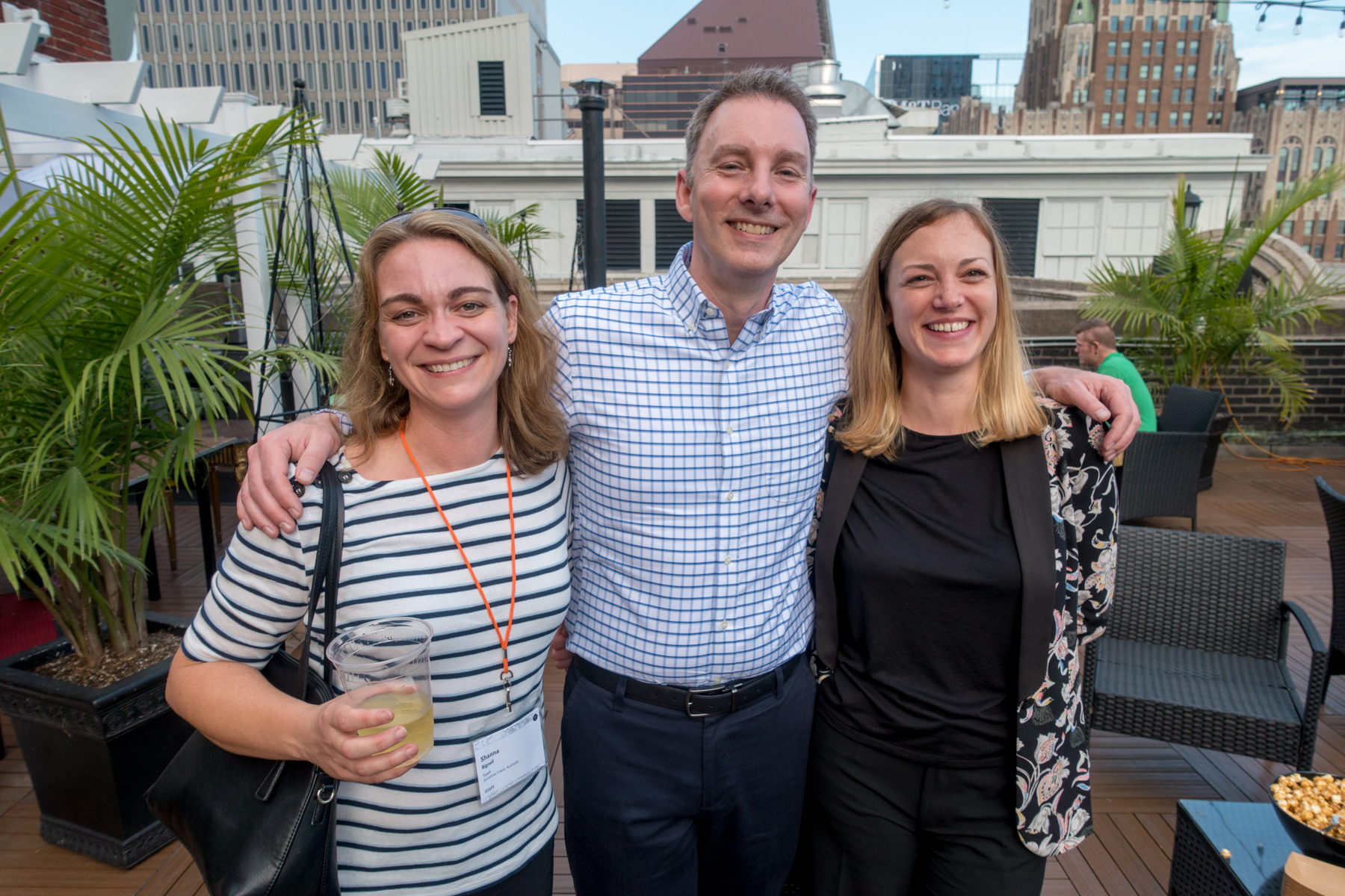 Shanna Bignell, Eric Damitz, and Marie Gollentz smile for the camera in the rooftop bar.