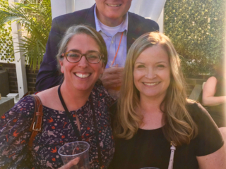 Smiley group shot of Jason Mitchell, Jennifer Moses and her friend enjoying drinks at the rooftop bar.