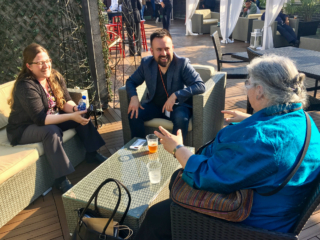 Christina Hampton and Karl Jankowski listen enthusiastically as Tommie Usdin makes a point over drinks in the rooftop bar.