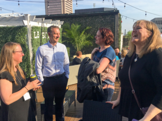 The group shares a laugh in the rooftop bar.