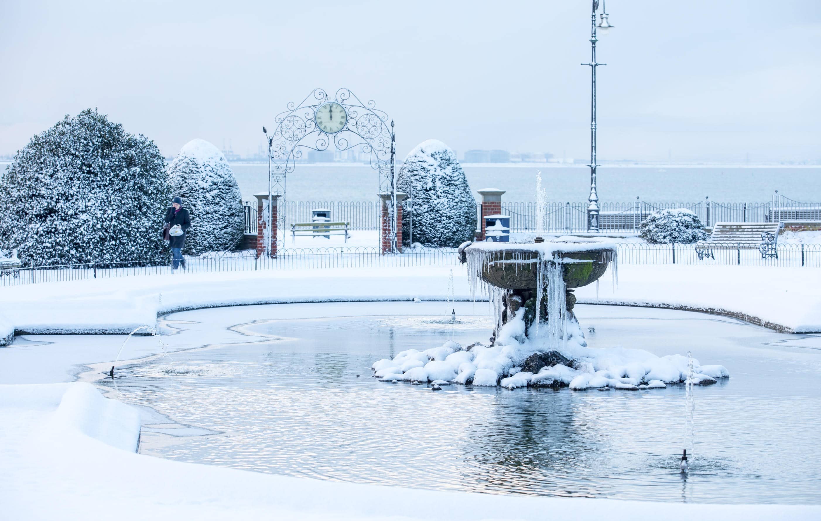 A frozen fountain in a snowy park in England.