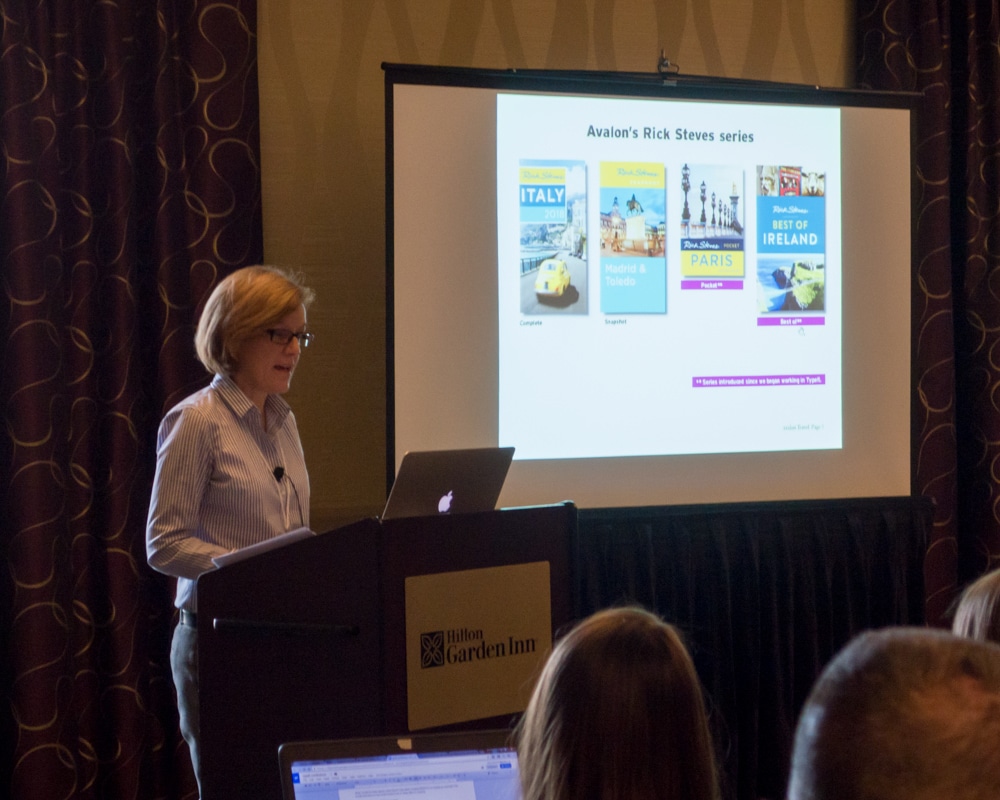 Jane Musser, VP Production at Avalon Travel, speaks to the audience at the 2017 Typefi User Conference. The screen behind her shows several titles from the Rick Steves travel guide series, including Italy, Madrid and Toledo, Paris, and the Best of Ireland.