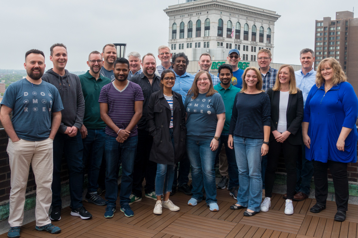 The Typefi team gathered in a rooftop courtyard with Baltimore buildings visible behind them.