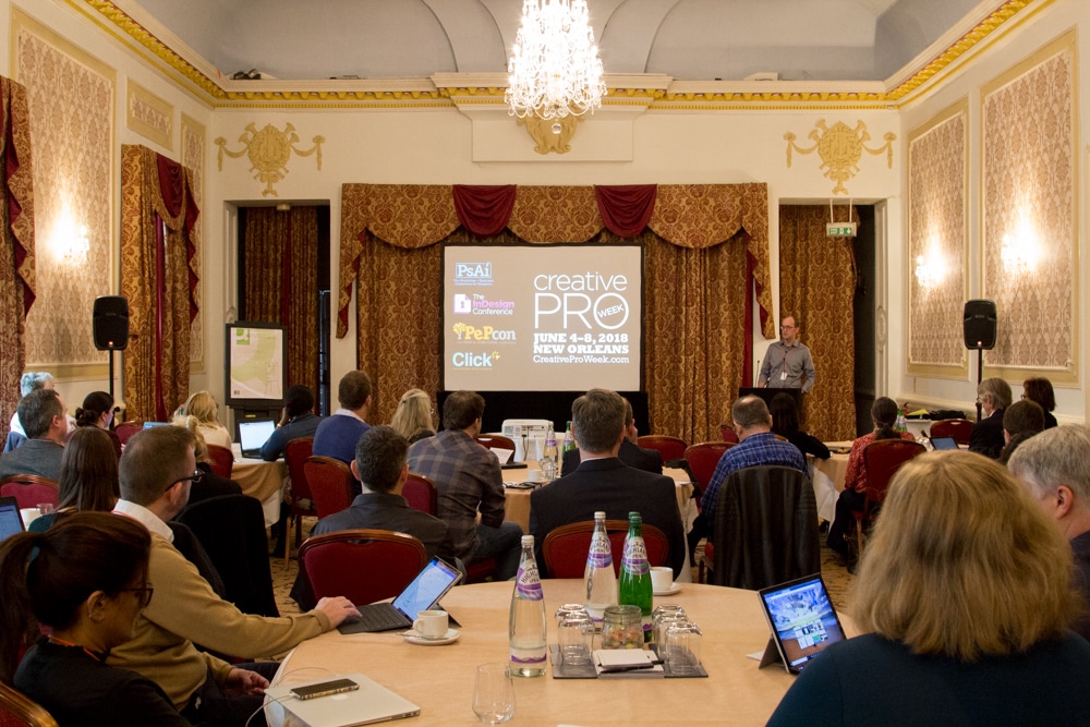 Caleb Clauset addressing the audience in the Paganini Ballroom, which is richly decorated in Regency style.