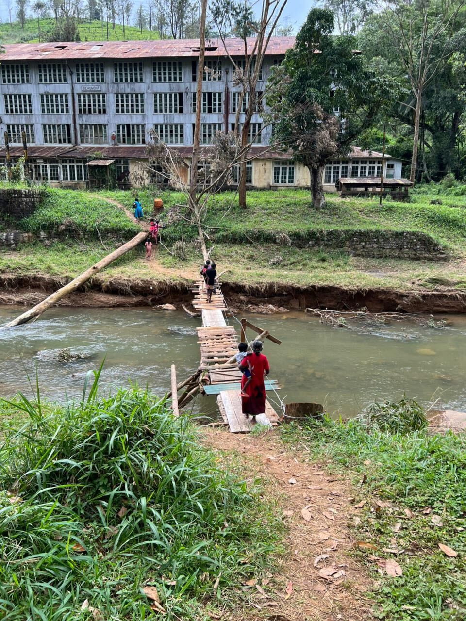 People using a makeshift bridge to cross a river in Sri Lanka.